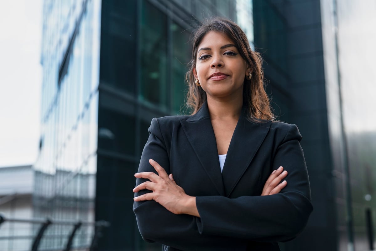 Confident Indian woman standing outside modern office building